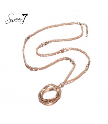 Lange ketting met naturelkleurige kralen met ronde hanger met steentjes