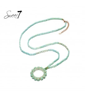 Lange ketting van groene kraaltjes met een ronde hanger met bloemen