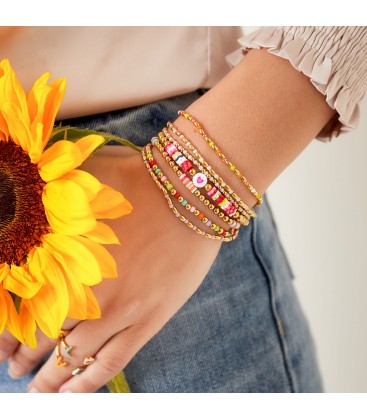 Armband met lange goudgekleurde kralen en kleine paarse kralen