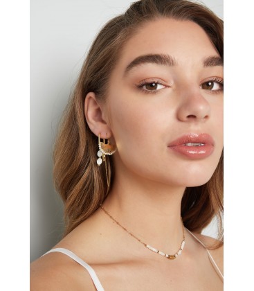 Zilverkleurige oorhangers in de vorm van een schelp en witte kraaltjes