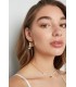 Zilverkleurige oorhangers in de vorm van een schelp en witte kraaltjes