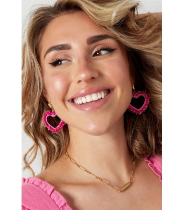 Fuchsia roze glas kralen oorhangers met koord en ene goudkleurig harten oorstukje