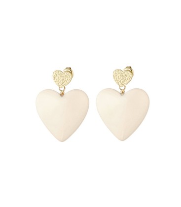 Beige harten oorhangers en een goudkleurig hartje