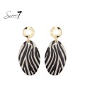 Zwart gekleurde oorhangers met print en een goudkleurig detail