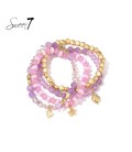 Paars gekleurde armband met goudkleurige bedels