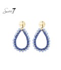Blauwe raffia oorbellen met een glas stenen rand
