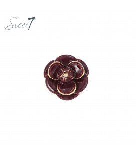 Broche met glanzende rode bloemblaadjes en goudkleurige rand