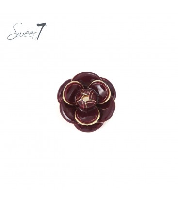 Broche met glanzende rode bloemblaadjes en goudkleurige rand