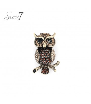 Goudkleurige uil broche gevuld met beige glas steentjes